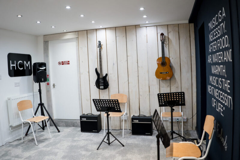 Part of a music room with guitars hanging on the wall