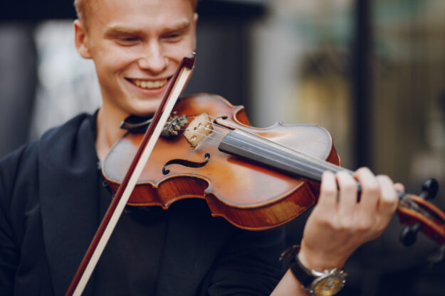 Close up of young man playing violin